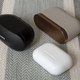 The charging case for the Sony WF-SP800Ns (black) compared to the case for the WF-1000XM3s (tan and gold) and the case for the Apple AirPods Pro (white).